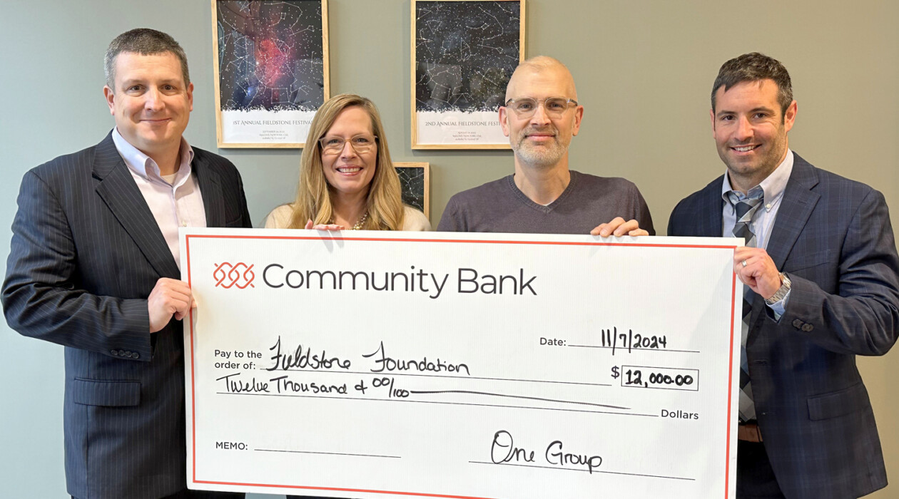 Representatives from Community Bank and OneGroup present a check to the Fieldstone Foundation.