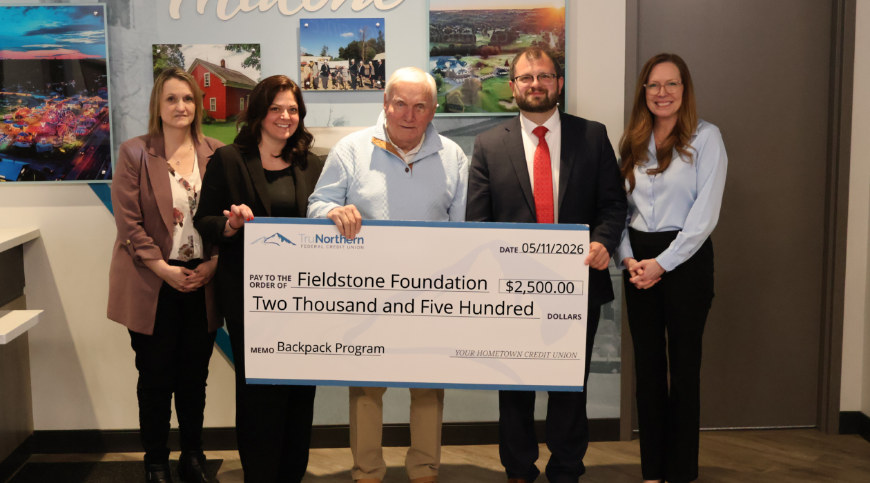 Representatives from TruNorthern Federal Credit Union present a donation to the Fieldstone Foundation Backpack Program honoring retiring board member Dick LaVigne.