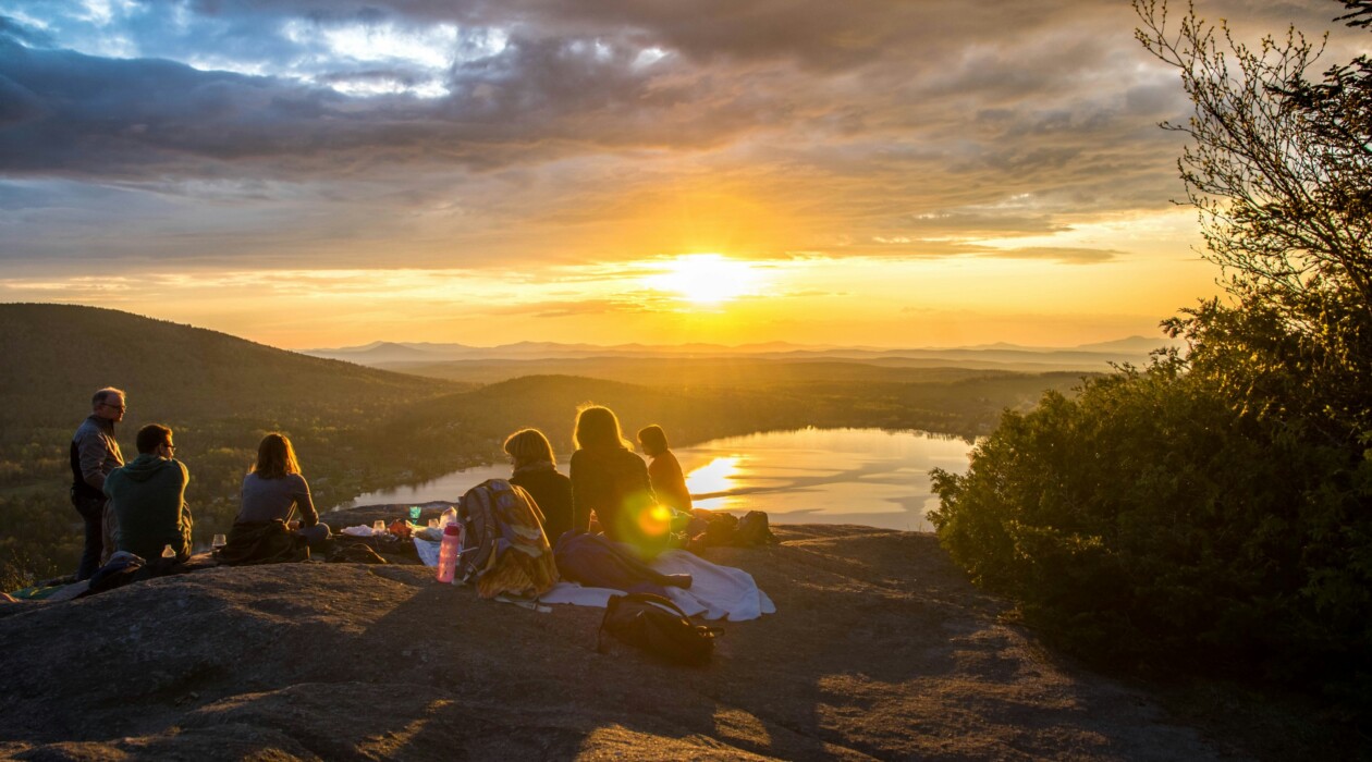 A group of friends enjoy a picnic on a mountaintop.